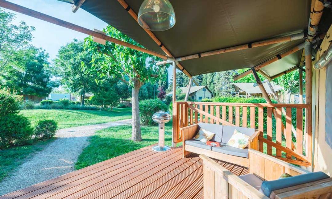 Træterrasse med udsigt over en grøn have.