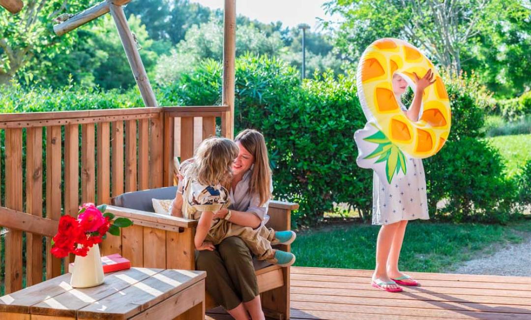 Glad familie på verandaen med barn og oppustelig donut.