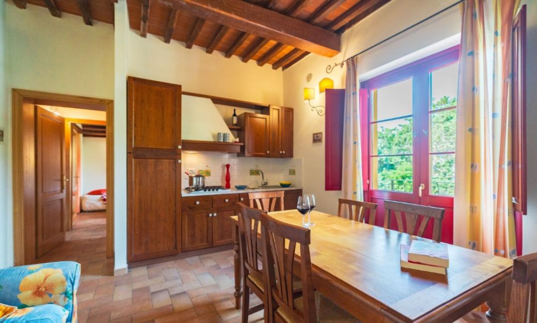 Cuisine rustique avec table à manger et vue sur le jardin.