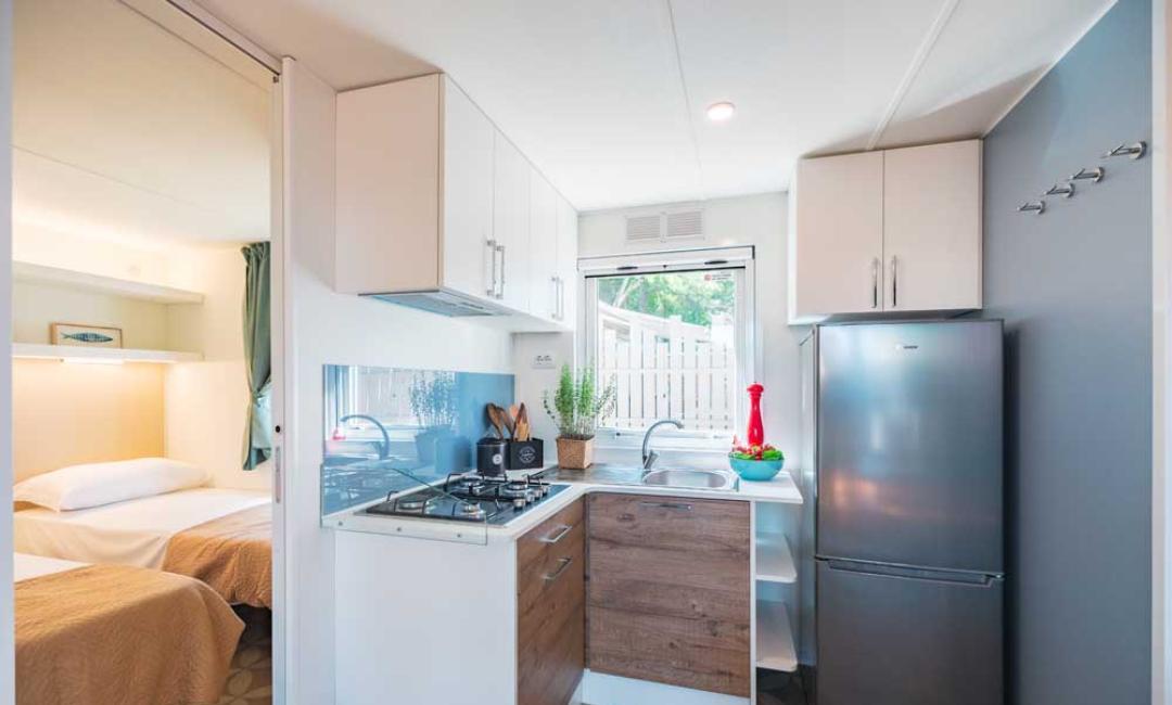 Petite cuisine moderne avec chambre adjacente.