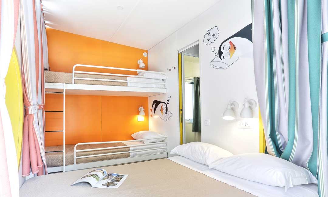 Colorful room with bunk beds and penguin decorations.