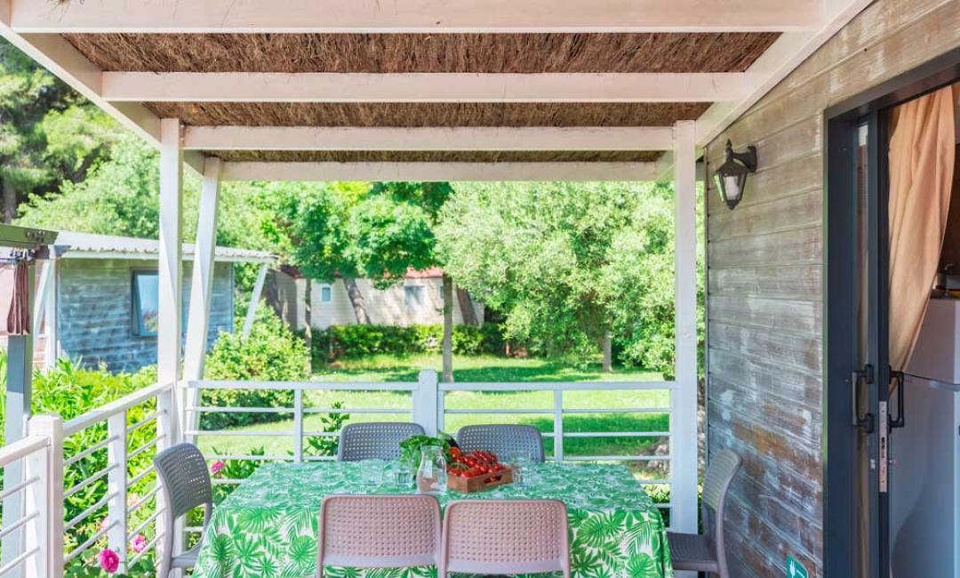 Veranda mit Tisch, Stühlen und Gartenblick.