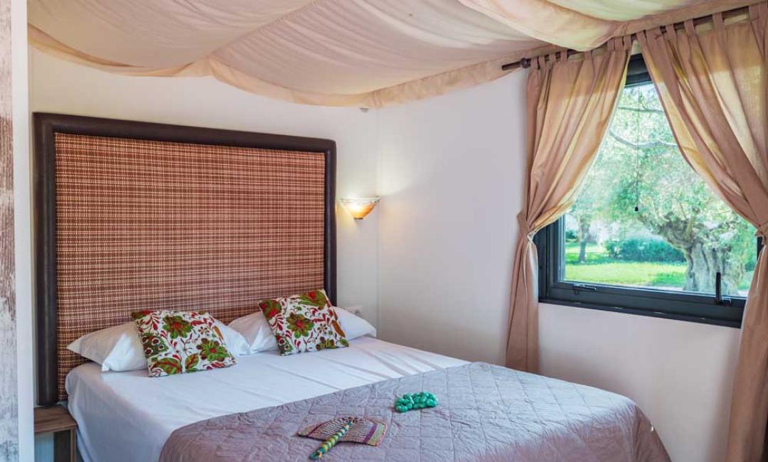 Gemütliches Zimmer mit Doppelbett und Gartenblick.