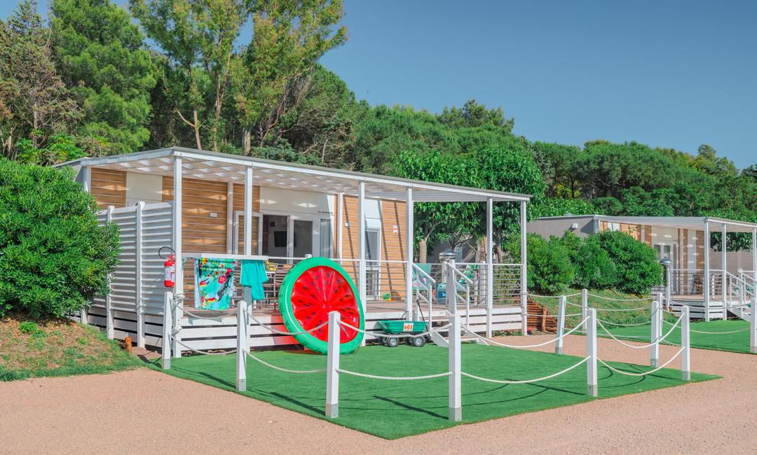 Moderne bungalow met veranda, omgeven door groene natuur.