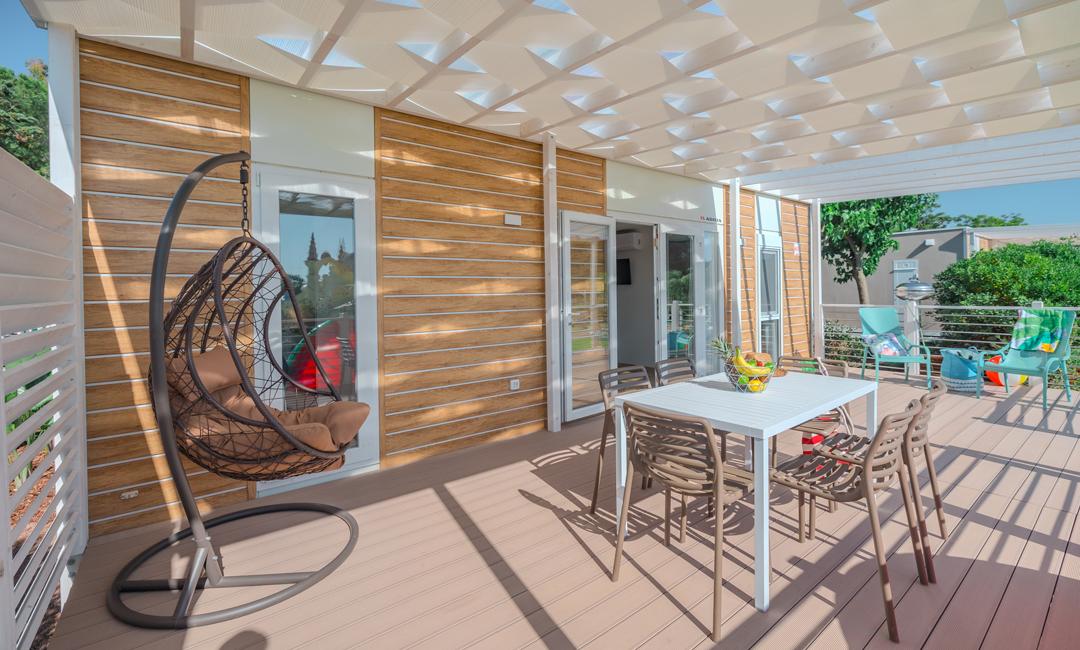 Moderne terras met stoelen, tafel en hangstoel.