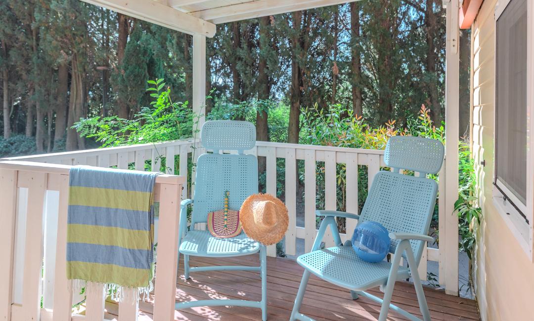 Cozy terrace with blue chairs, hat, and ball.