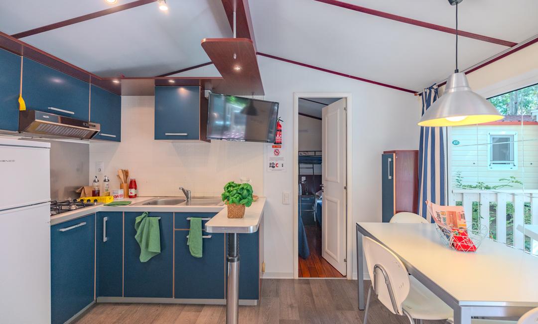 Modern kitchen with kitchenette, dining table, and wall-mounted TV.