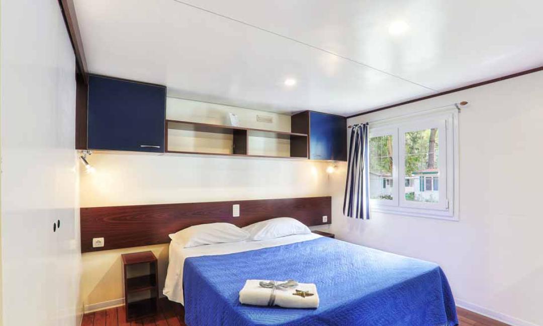 Helles Schlafzimmer mit Doppelbett und Fenster.