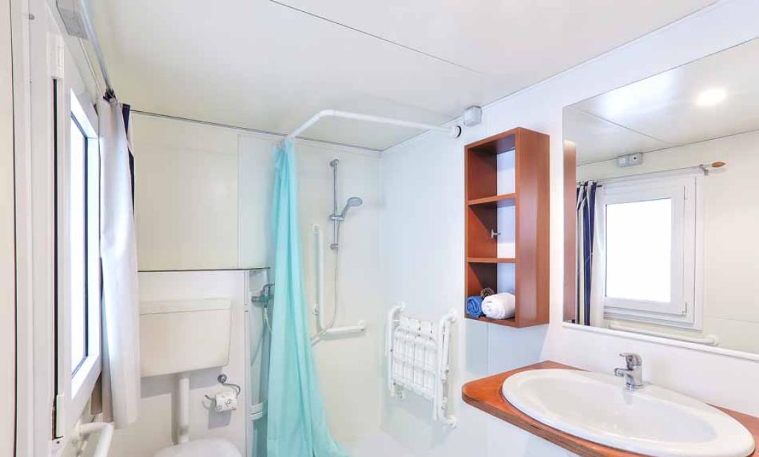 Modernes Badezimmer mit Dusche, Waschbecken und Holzregal.