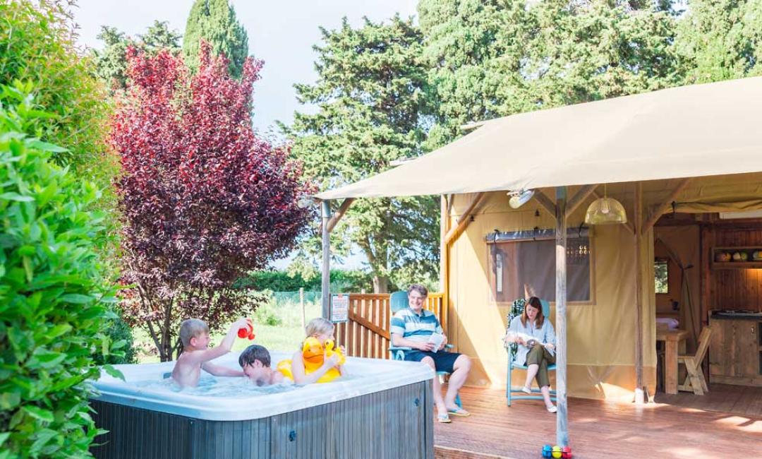 Familie entspannt in einem Glamping-Zelt mit Whirlpool.