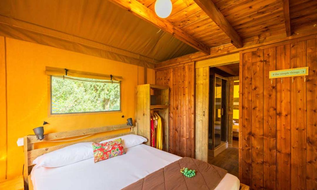 Gemütliches Zimmer mit Holzbett und Panoramafenster.