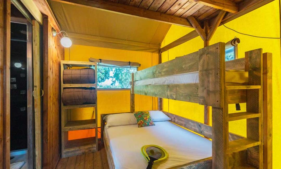 Gemütliches Zimmer mit Holz-Etagenbett und gelben Wänden.