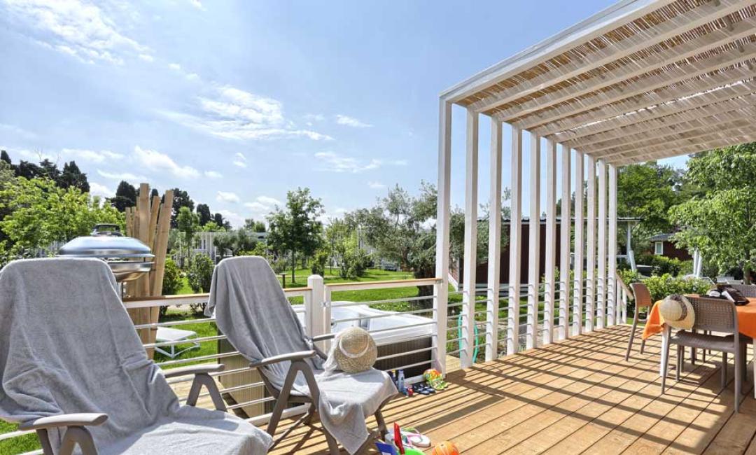 Terrasse ensoleillée avec chaises, table et jouets pour enfants.